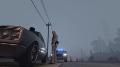 A trooper talks to the driver of a disabled vehicle while they await a tow truck