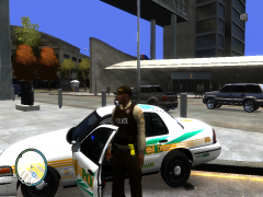 Miami-Dade Officer stands next to his cruiser