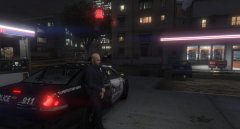 An officer fuels his patrol car and takes cover from the rain.