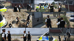 Officers outside the raided premises of known drug dealers where 4 were arrested
